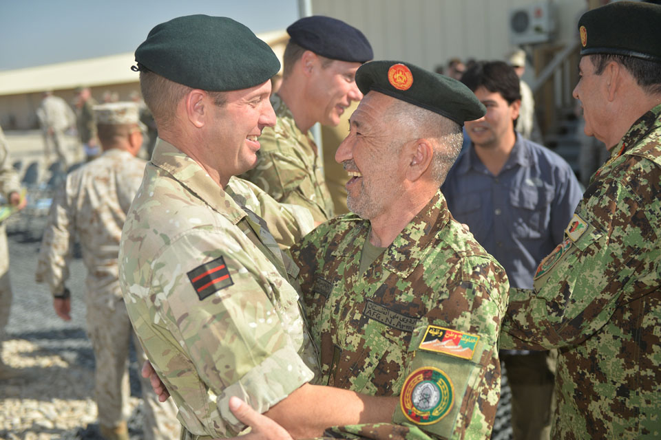 Brigadier Rob Thomson, Deputy Commander of Regional Command South West, embraces a senior Afghan official during the End of Operations Ceremony.