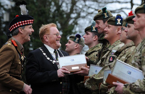 Provost Fergus Wood presents Corporal Robert Storrie of 5th Battalion The Royal Regiment of Scotland with a copy of the Freedom of the City Scroll. Looking on is Colonel of the Regiment, Lieutenant General Andrew Graham