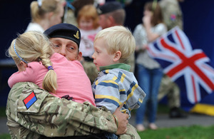 A soldier from the 19th Regiment Royal Artillery holds his children