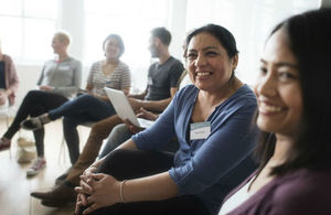Group of people sat in a circle in a seminar listening to ideas