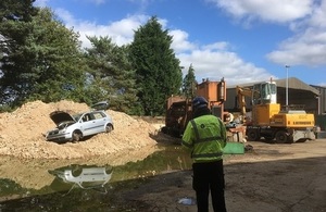 A waste site in the Thames Valley showing an Environment Officer and an old car.