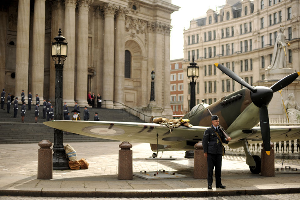 A re-enactor dressed as a wartime airman guards a replica Spitfire outside St Paul's Cathedral in London as a special service is conducted to commemorate the 70th anniversary of the Battle of Britain