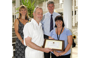 Commodore Adrian Bell presents Stacey Cooper with an award for her work in Afghanistan in 2009