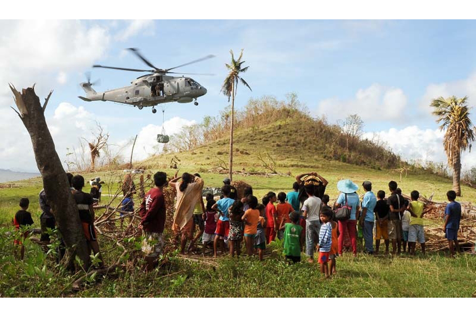 A Merlin helicopter delivers aid to communities on Sicogon Island