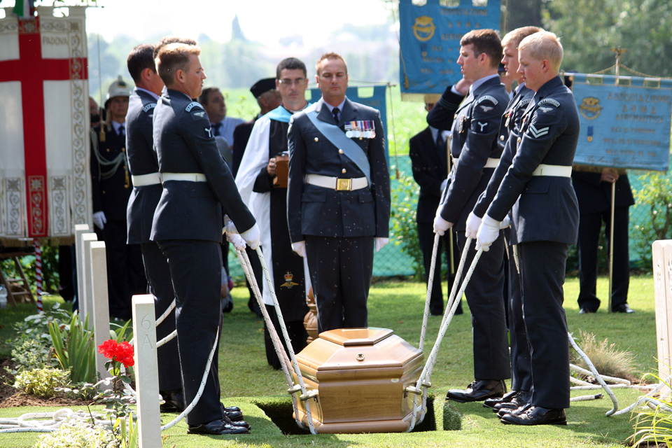 Members of the Queen's Colour Squadron lower the coffin into the grave 