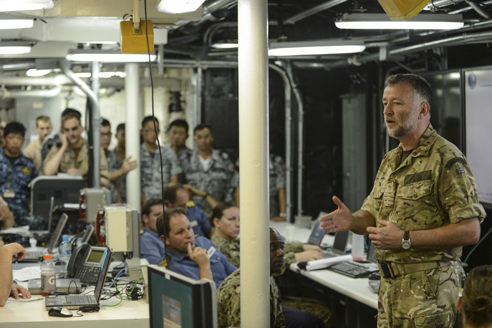 Captain Andy Elvin speaks to multinational Service personnel