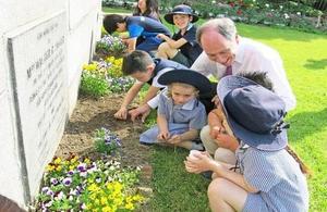 British & Korean schoolchildren plants poppies in the Residence garden