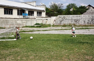 Kids playing football on an abandoned pitch.