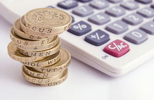 Pile of pound coins with calculator. Copyright iStock.