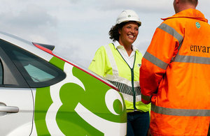 Environment Agency staff talking outside by an Environment Agency vehicle.