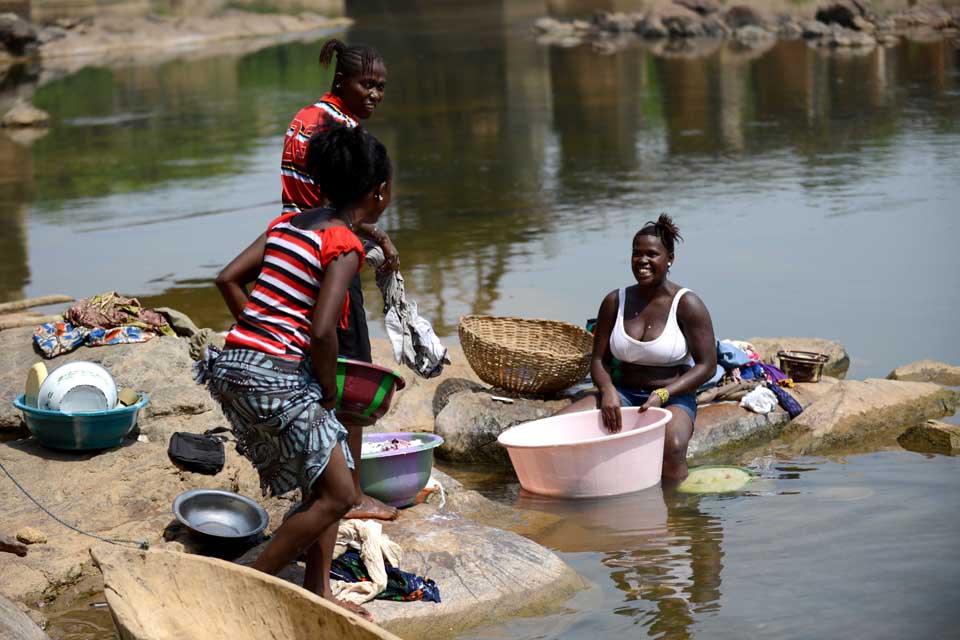 Women washing clothes by a river in Sierra Leone