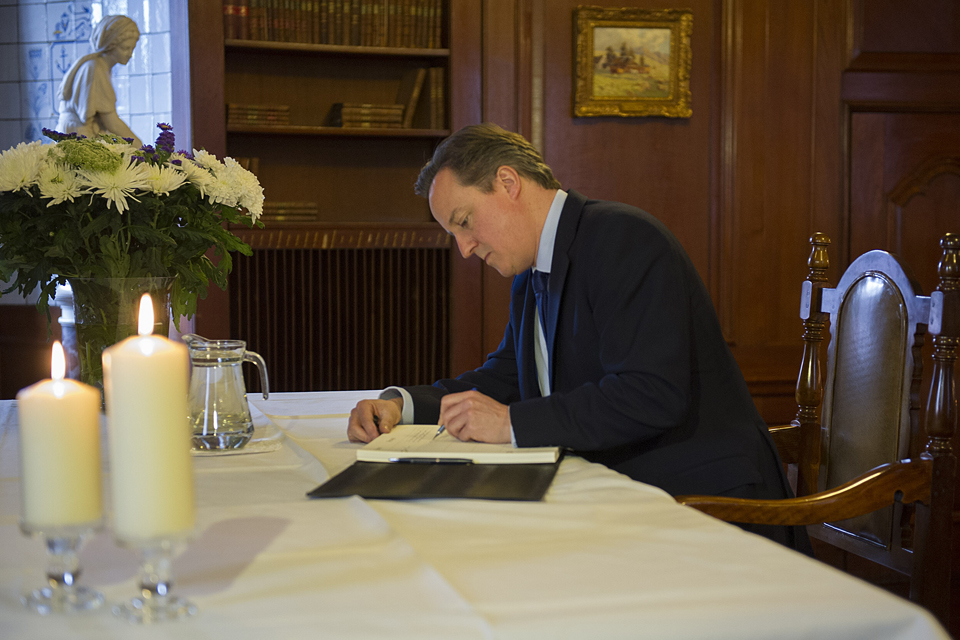 David Cameron writes in the book of condolence for Nelson Mandela at South Africa House