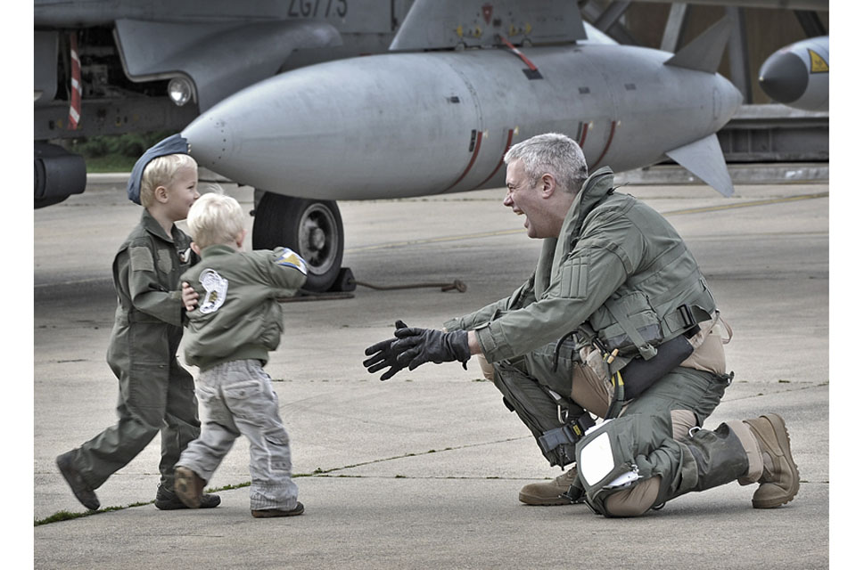 Wing Commander Andy Turk, Officer Commanding IX (Bomber) Squadron, is welcomed home by his sons  