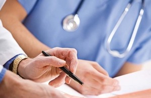 Close up of nurse uniform, stethoscope and paperwork