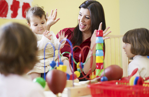 Nursery teacher and children playing.