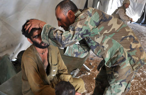 Afghan National Army Staff Sergeant Dur Mohammad treats a visitor to the Village Medical Outreach clinic