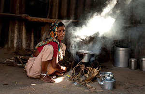 Woman cooks dinner for her family on traditional open fire in Gujarat, India.