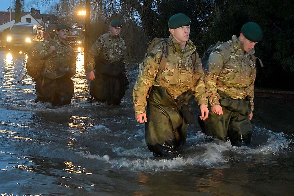 Royal Marines wade through a flooded street