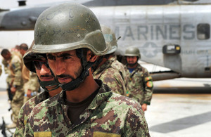 British and Afghan troops wait to board an ISAF helicopter