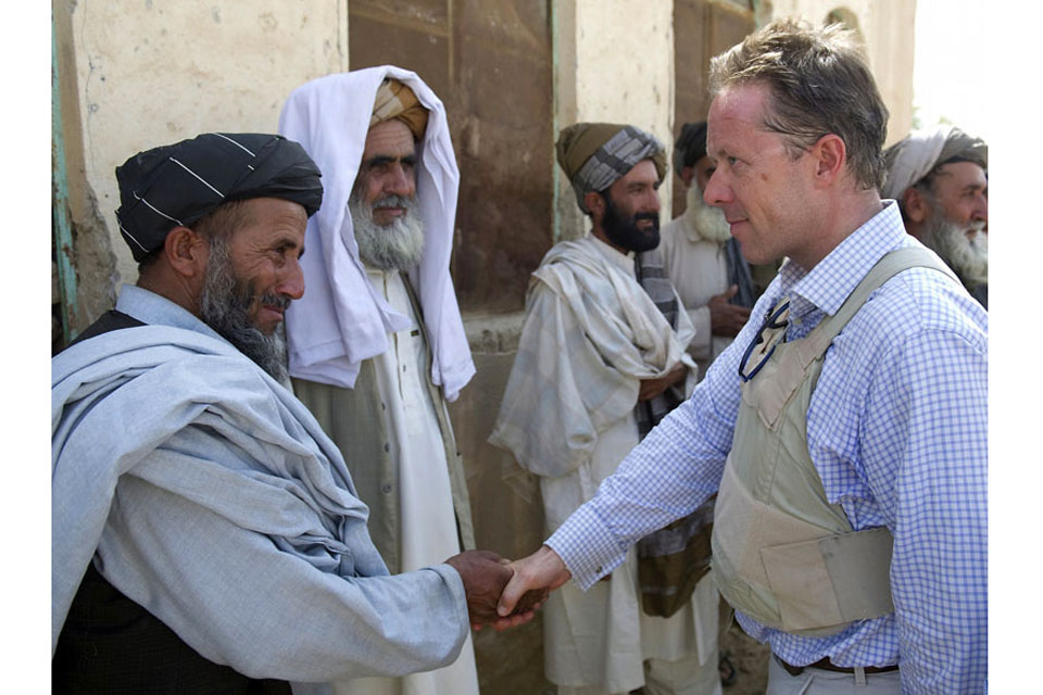 Mr Michael O'Neill greets local Afghans on his arrival at a school they want to rebuild in Naqilabad  
