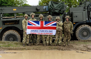 Soldiers next to Armed Forces Day flag