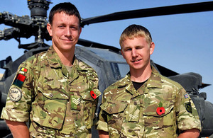 Brothers Staff Sergeant Ray Neenan and Corporal Darren Neenan in front of an Army Air Corps Apache attack helicopter at Camp Bastion in Helmand province