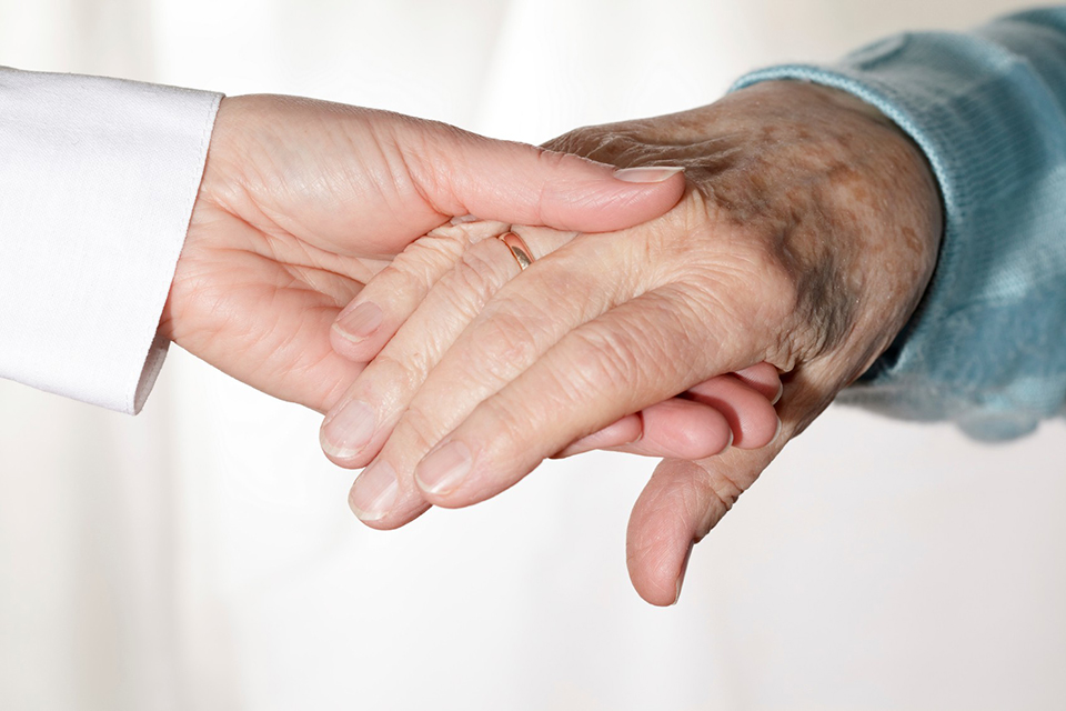 a young person and an old person holding hands