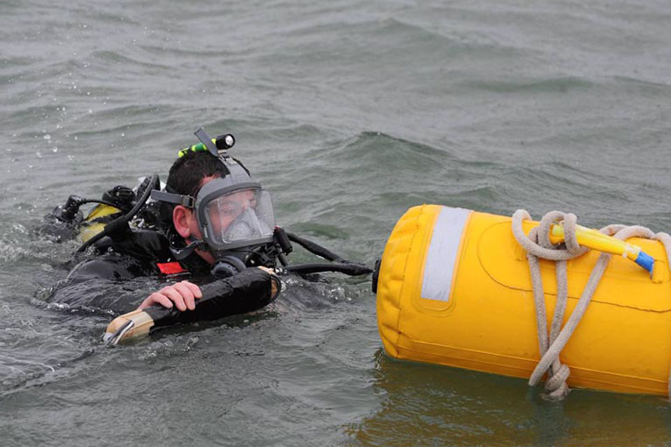 A Royal Navy diver prepares to dive to the bomb in Plymouth Sound in order to set the explosive charges 