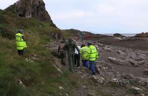 One of the male casualties walks towards HMS Gannet's Search and Rescue helicopter