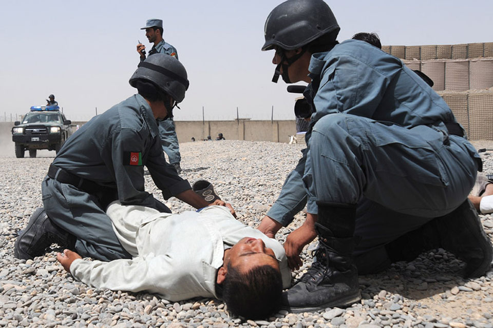 Afghan National Police recruits taking part in an exercise perform casualty drills in a mock Bazaar 