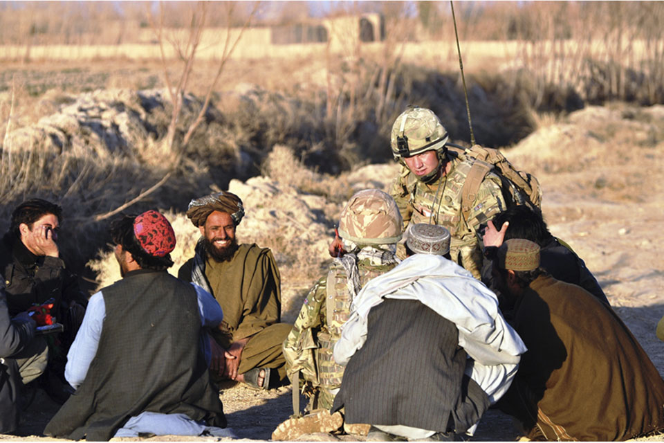 Corporal Jamie Williams speaks with Afghan men in Alokozi Shah, south of Popalzai Kalay, near Helmand's capital, Lashkar Gah 