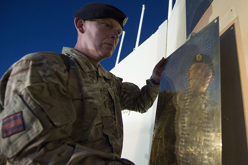 A name plaque is taken down from the memorial wall 