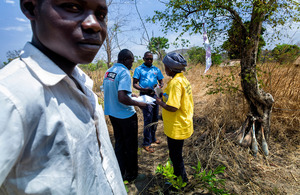 Michael Bernado pictured with a MAG community liasion team close to unexploded grenades found near his village in South Sudan. Photo: MAG International / Sean Sutton