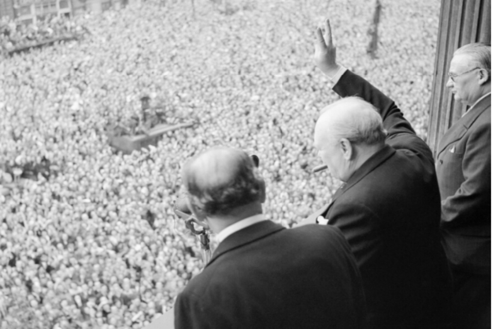 Winston Churchill waves to crowds in Whitehall on the day he broadcast to the nation that the war with Germany had been won, 8 May 1945 (VE Day). [Picture: Imperial War Museum H 41849]