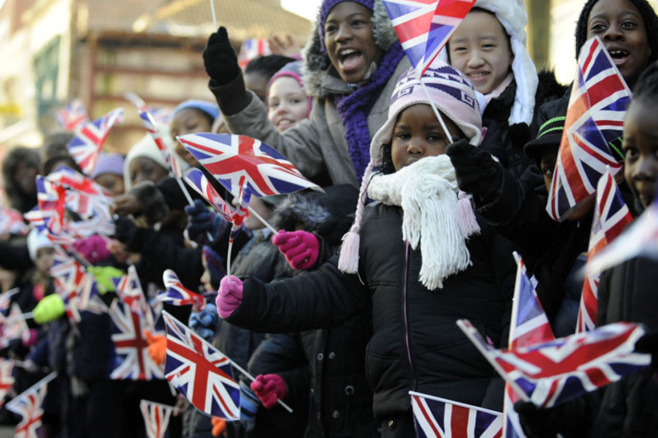 Hundreds of excited schoolchildren, waving flags, lined the streets of Woolwich to watch the parade 