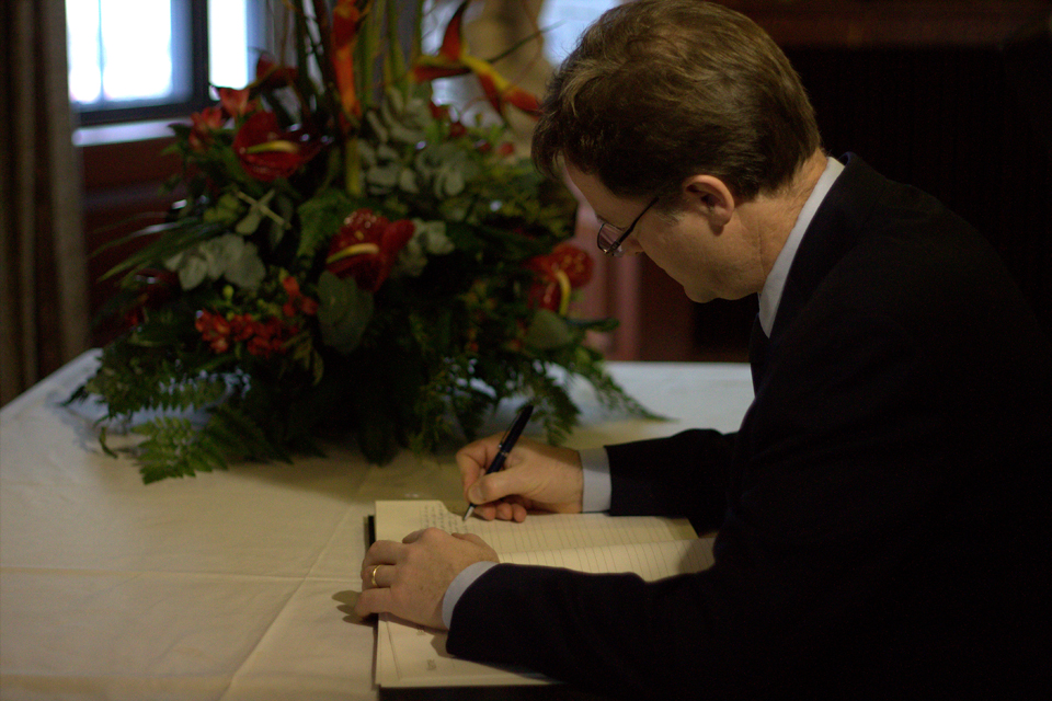 Nick Clegg signing a book of condolence for Nelson Mandela at South Africa House.