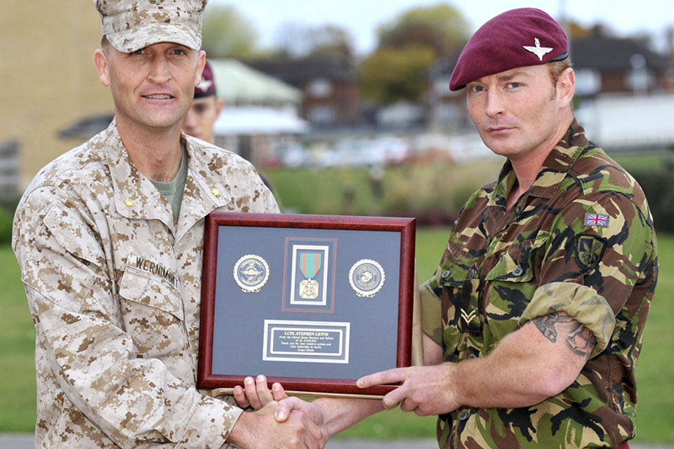 Major Timothy Wernimont, United States Marine Corps, presents Lance Corporal Stephen Lewis, 2nd Battalion The Parachute Regiment, with the (US) Navy and Marine Corps Achievement Medal  