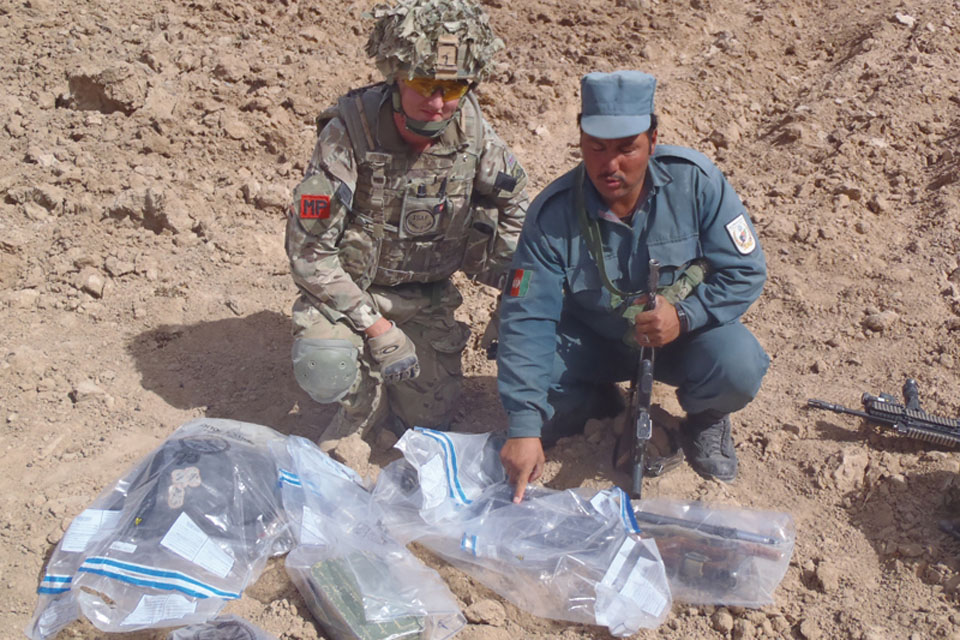 Training a member of the Afghan Uniform Police in how to gather and record evidence