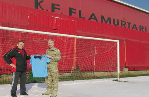 Lieutenant Colonel David Jones presenting the football strips to Mr Fatmir Ibrahimi, Football Club Flamurtari Youth Team coach