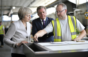 Prime Minister Theresa May speaking with Martek Designs Managing Director Derek Galloway and an employee.