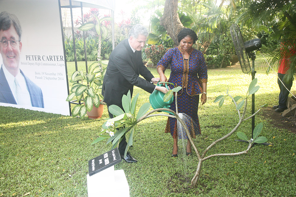 watering the tree planted in the garden of the British residence in honour of Peter Carter