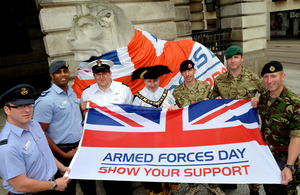 Armed Forces personnel with Armed Forces Day flag