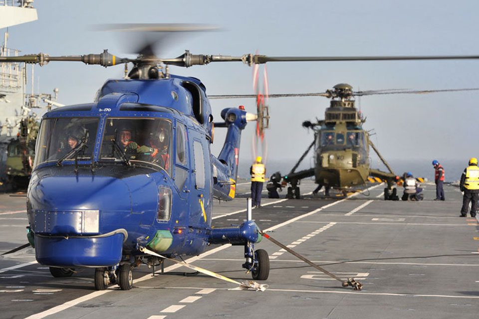 A Lynx helicopter from the Royal Danish Air Force (foreground) on board HMS Illustrious for flight deck drills