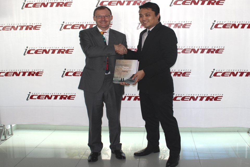 H.E Rob Fenn presenting Jeremy, Manager for the iCentre, with Thomas Heatherwick's book "Making"