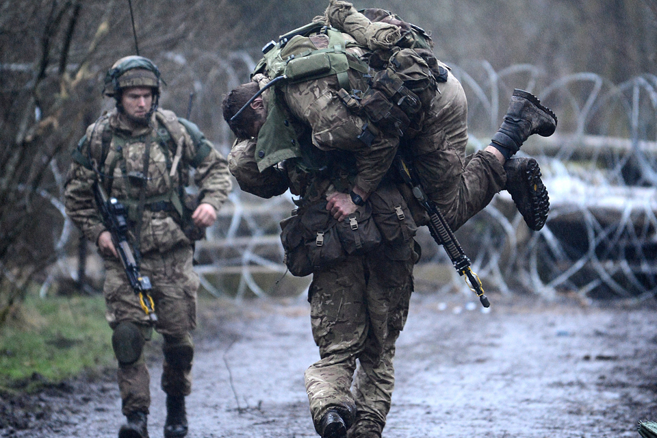 A Royal Marine evacuates a casualty 