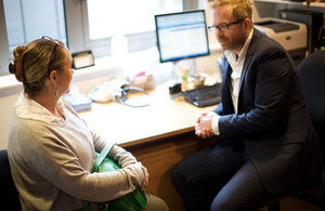 Male GP talking to a female patient