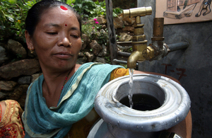 A woman collects clean water from a tap in Nepal. Picture: AusAid/Jim Holmes