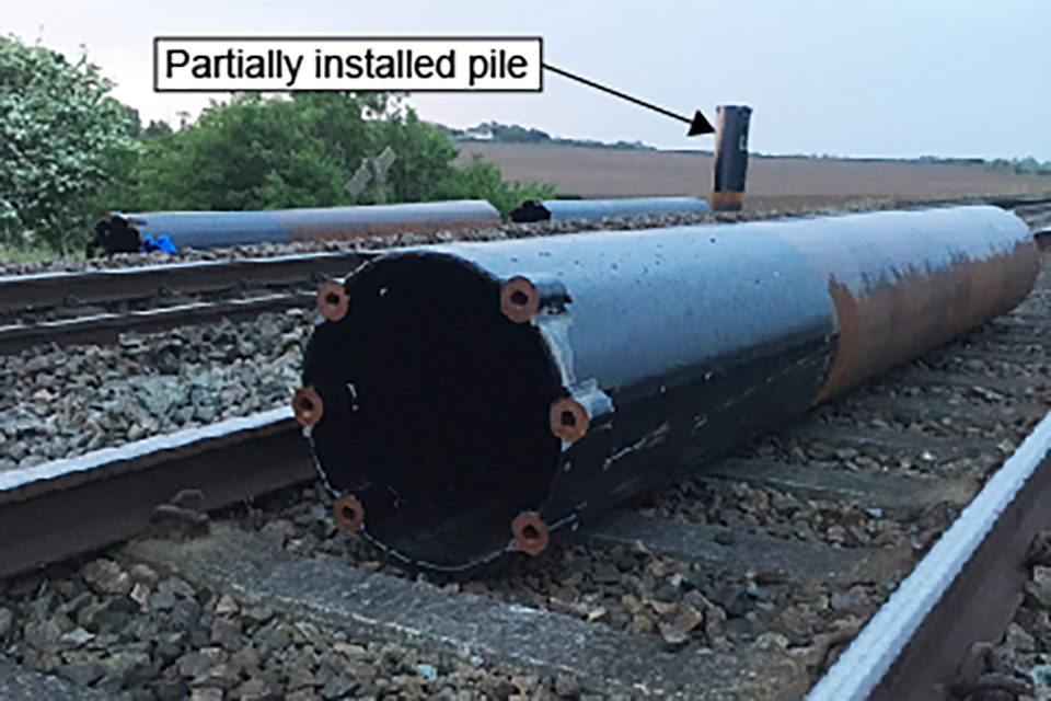 The pile lying in the four foot as found by the tamper driver (image courtesy of Network Rail). The partially installed pile is standing in the cess