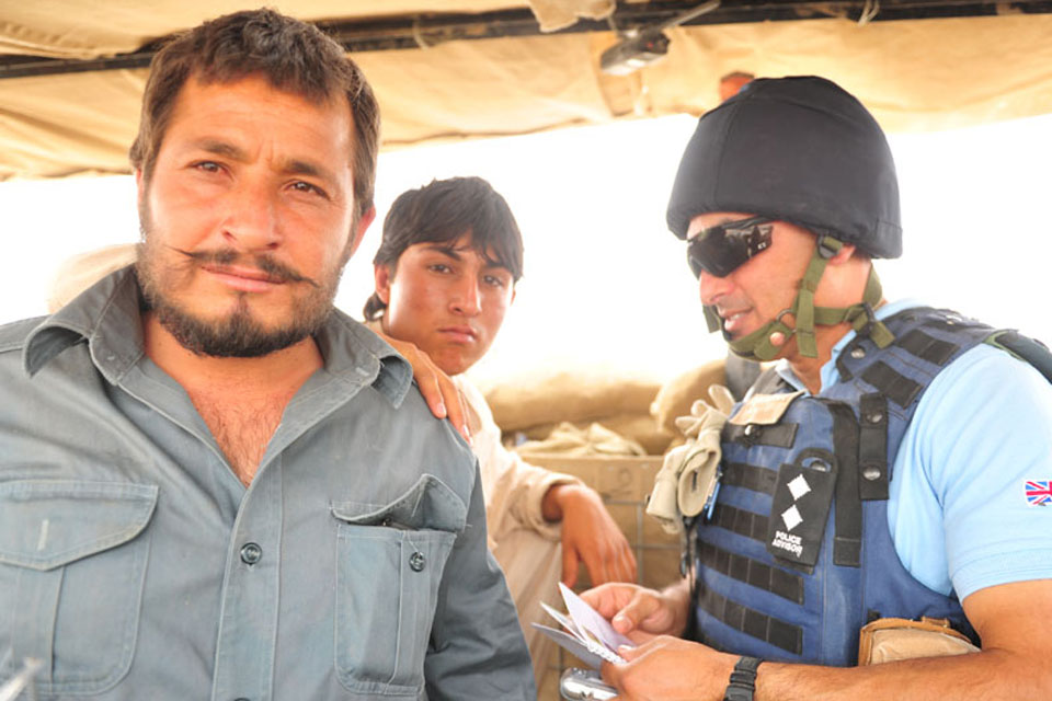 Ministry of Defence Police Inspector Tony Micallef looks in on Afghan Police at Checkpoint Noorzai 