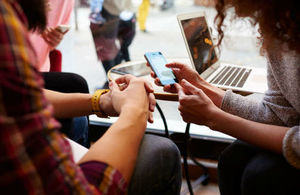 A women and friend interact with a smart phone together